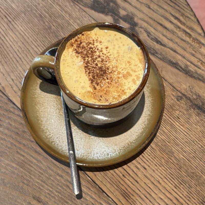 A cup of egg coffee dusted with cinnamon